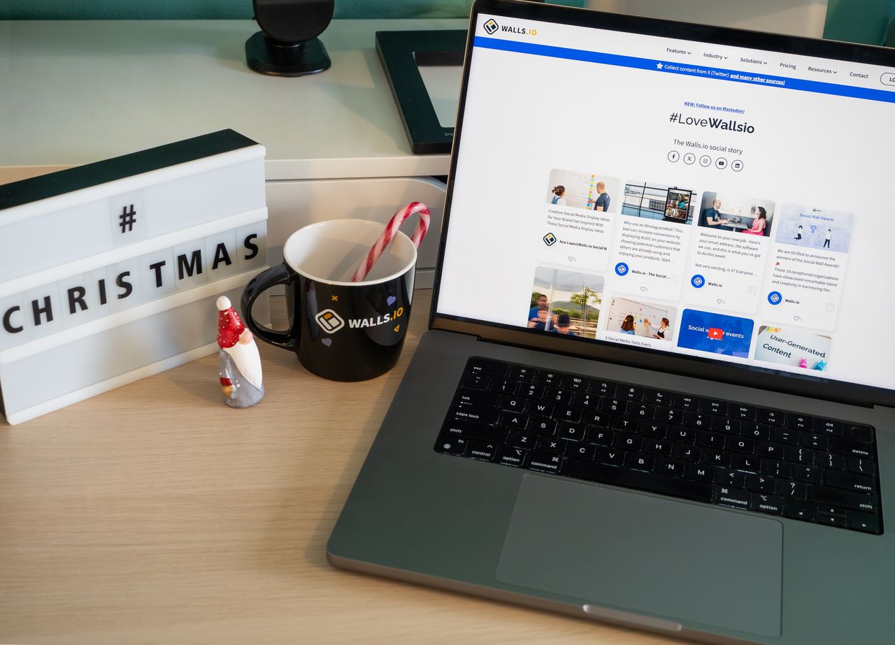 Un bureau chaleureux décoré pour Noël, avec une tasse et un écran d’ordinateur portable affichant un site web.